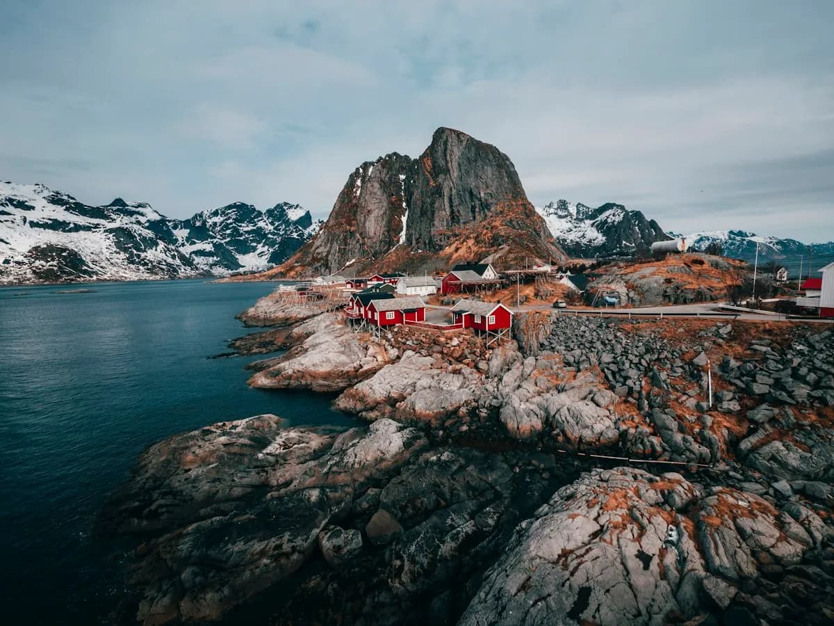 A coastal village framed by rocky mountain peaks